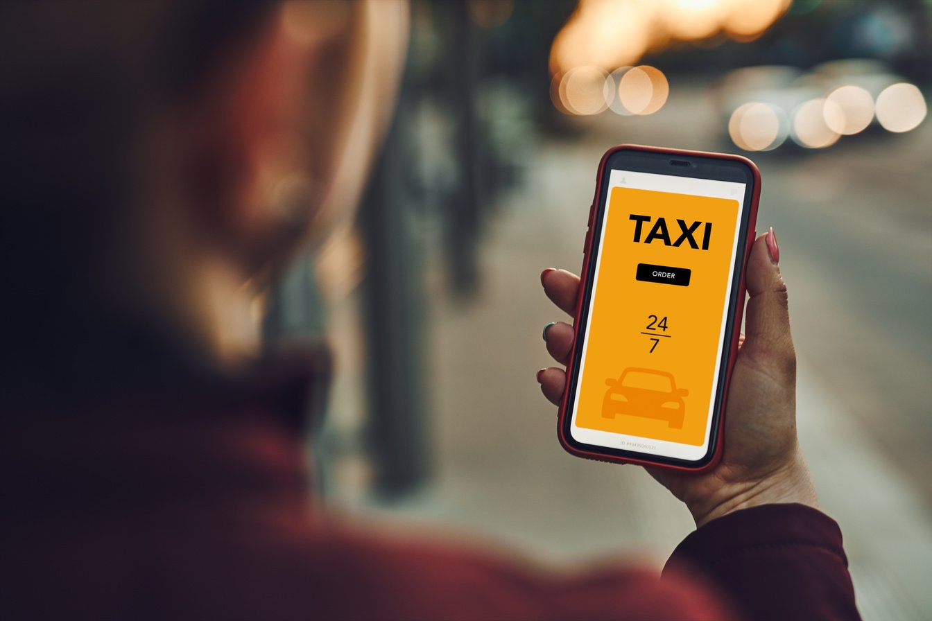 Woman ordering taxi online using mobile app on smart phone.